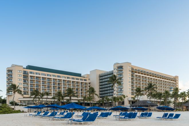 Hilton Hotel Exterior and Lounge Chairs under Umbrellas at the Beach