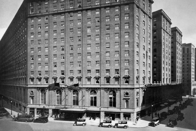 Historisches Schwarz-Weiß-Foto von der Außenansicht des Hotels und Blick auf die Straße mit Oldtimern