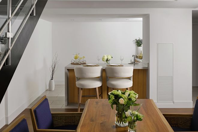 a dining table next to a staircase