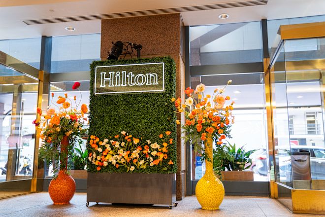 Hilton Sign and Large Bases with Yellow and Orange Poppy Flowers at The Lobby Bar