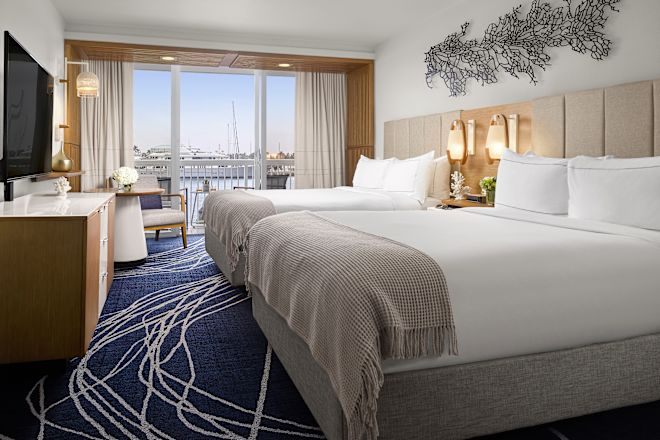 two beds in a guest room with a balcony