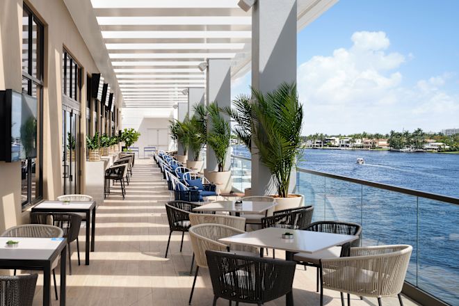 Restaurant seating area with tables and chairs by the sea