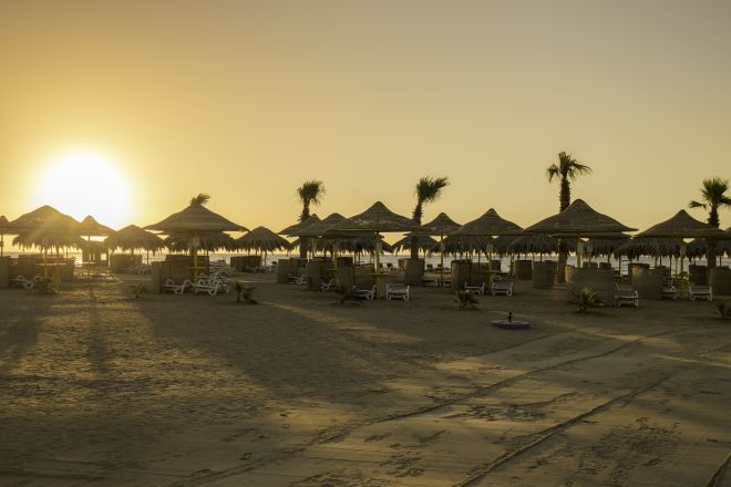 Sunrise at Beach Area with Straw Umbrellas