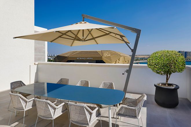 ロイヤルスイートのテラスのパラソルの下に椅子を配したテーブル