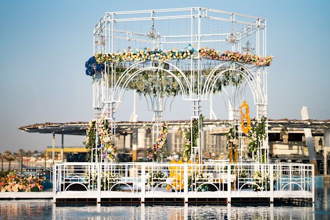 花々で飾られた海辺のアーチエリアでウェディングをお祝い