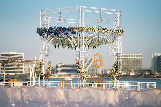 花々で飾られた海辺のアーチエリアでウェディングをお祝い