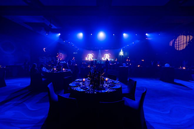 イベント用に円卓を備えたダークミーティングルームの人々