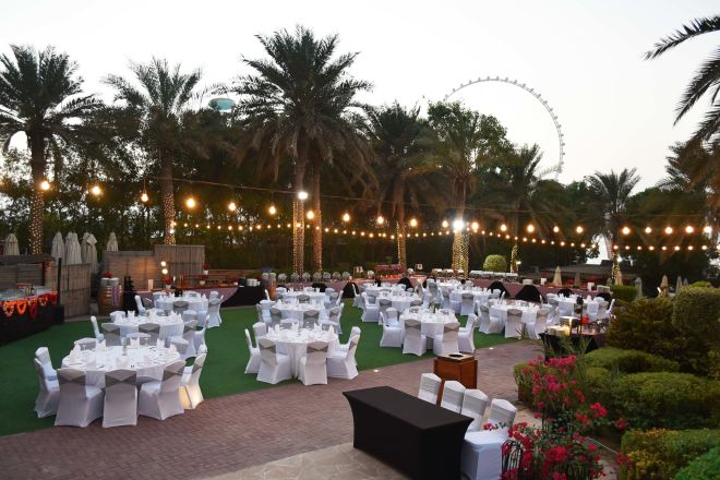 Garden in the evening setup with round tables for an event