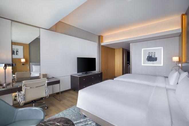 Chambre avec lits jumeaux, téléviseur et bureau