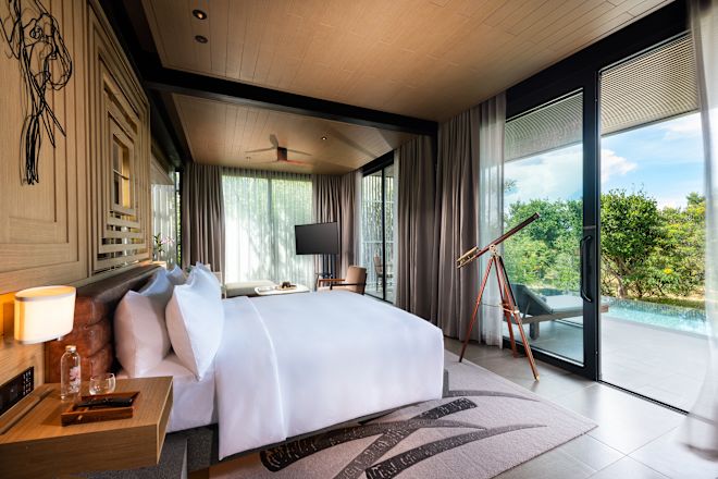 Cama grande en una suite con piscina