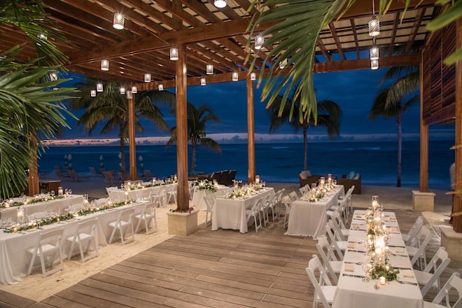 Wedding table setup under beach hut with ocean behind