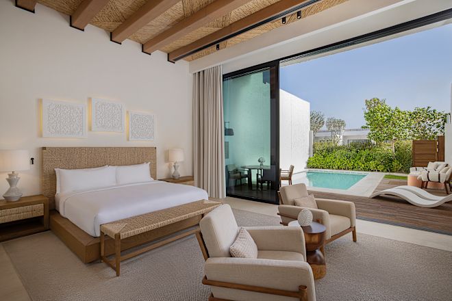 Schlafzimmer der Suite mit Blick auf den Außenpoolbereich