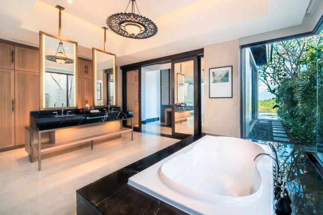 Bathroom area with tub and sinks