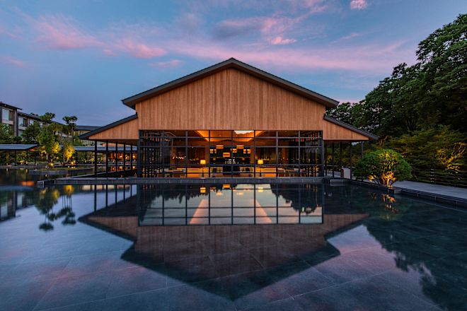 Restaurant area with tables and chairs, with water basin in foreground