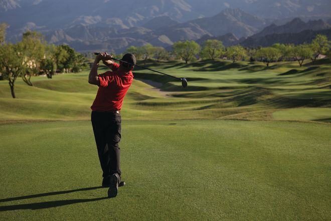 Golfer Swinging Club on Golf Course