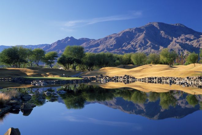Panoramic view over a lake with mountains in the background. Location is TPC Stadium Course at PGA WEST