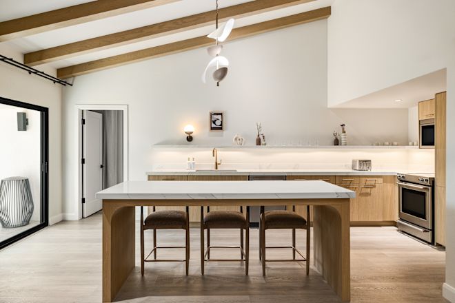 Serene guest villa kitchen with large marble island and stools