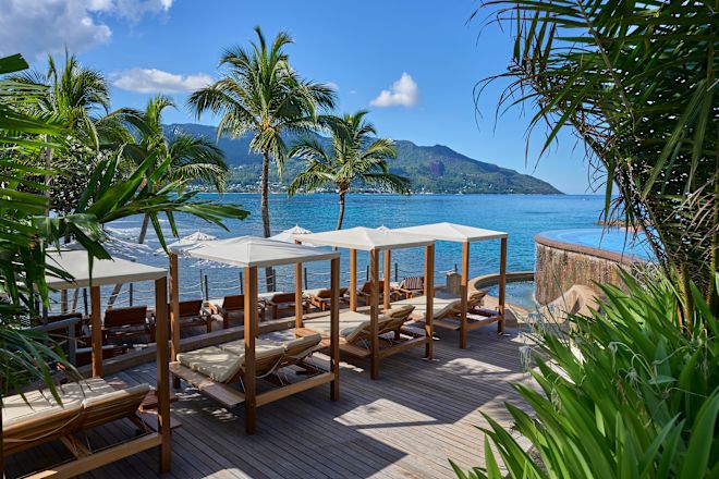 Khu vực chỗ ngồi ngoài trời với ghế dài, cây cối và biển