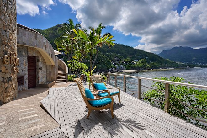 Khu vực chỗ ngồi ngoài trời với ghế nhìn ra biển và những cây xung quanh