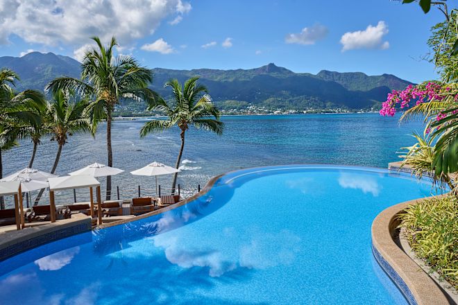 Bể bơi ngoài trời với cây cối, tầm nhìn ra biển và những đám mây trên bầu trời