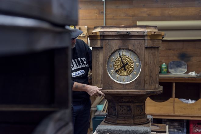 man fixing the old lobby clock exterior