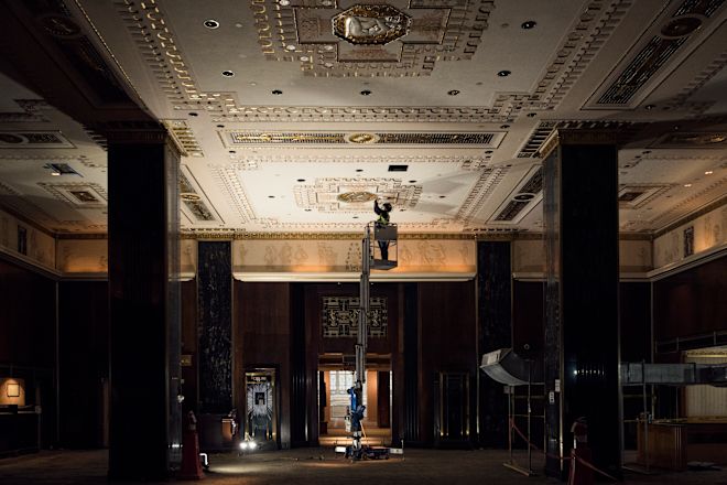 man on a lift restoring the lobby ceiling of the Waldorf Astoria New York