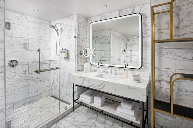 Modern marble bathroom with sink, towels and walk-in shower