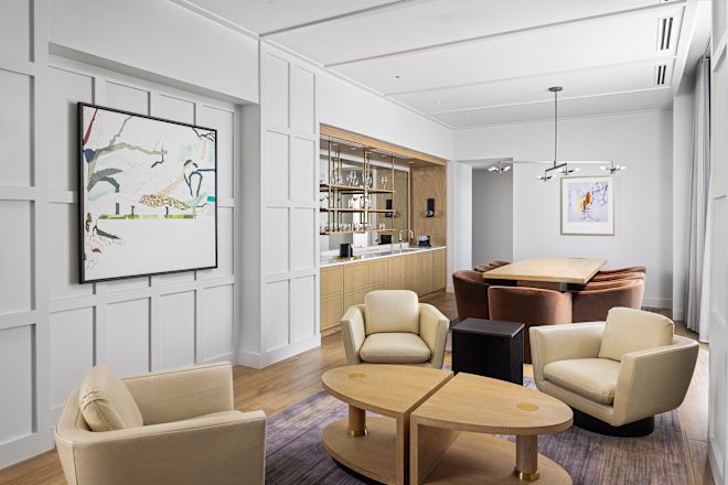 Guestroom lounge area with tables, chairs and art on wall