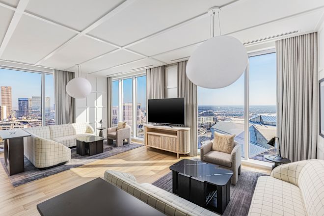 Guestroom lounge area with sofas, tables and TV