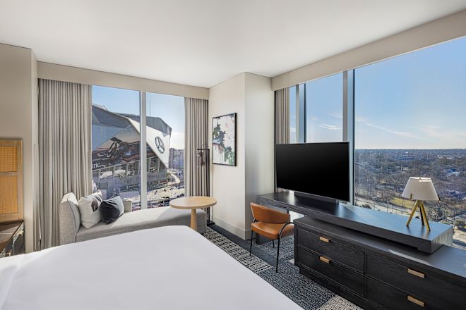 Guestroom with bed, work desk and TV