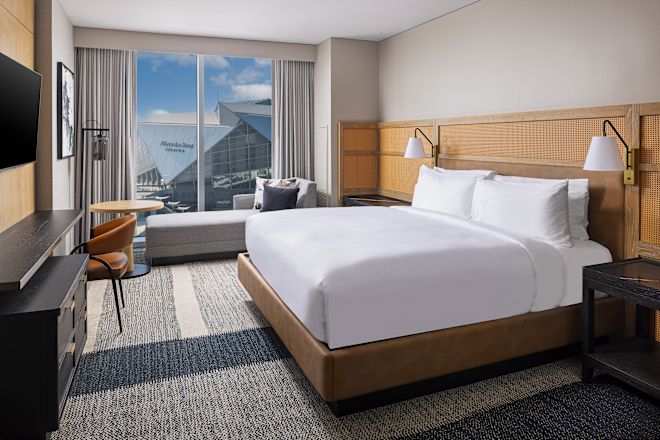 Guestroom with bed, work desk and TV