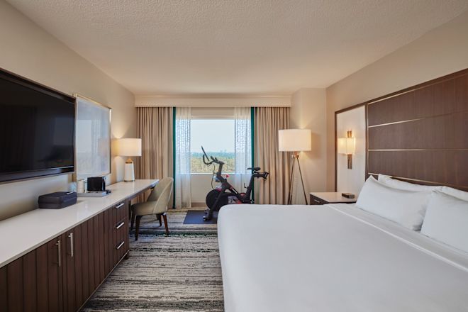 Bed in room with TV and exercise equipment