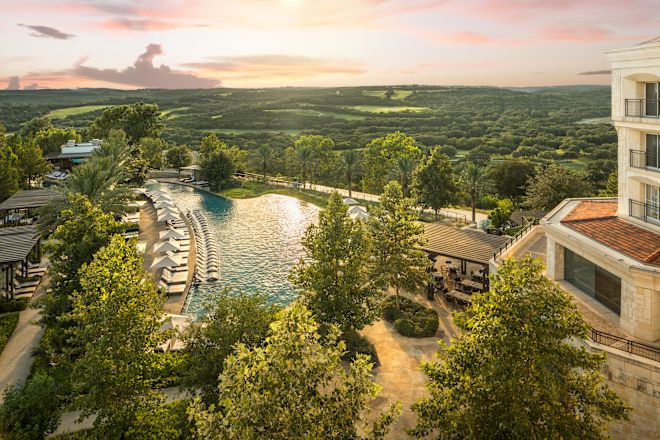 Hotel exterior, with outdoor pool with loungers and trees