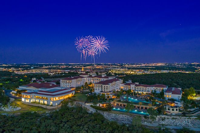 Aerial view of hotel and grounds at night with fireworks in the sky