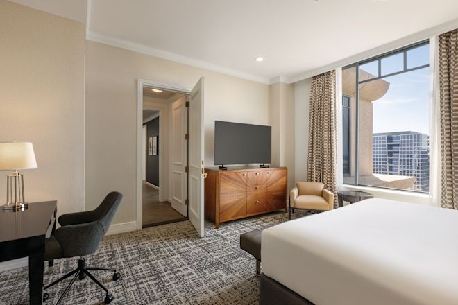 suite bedroom with desk and tv
