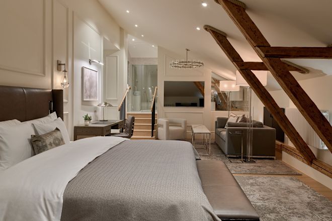 غرفة نزلاء بها سرير، ومكتب عمل، ومنطقة جلوس، وتلفزيون