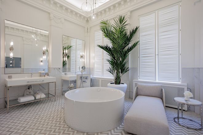 حمام جناح كبير به حوض استحمام عميق كبير الحجم، ومنضدة تزيين مزدوجة، وشيزلونج، ونوافذ