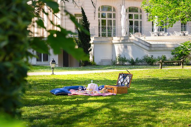 Coș și mâncare într-o configurație de gazon pentru un picnic la Pique Nique