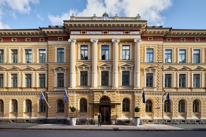 واجهة الفندق مع علم يرفرف وحارس يقف في الخارج