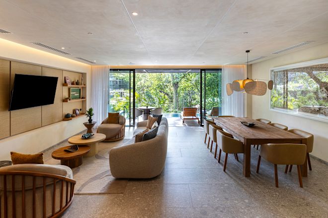 Wohnbereich der Pacifico Suite, Sofa, Fernseher, Esstisch, Fensterblick auf die private Terrasse und den Swimmingpool