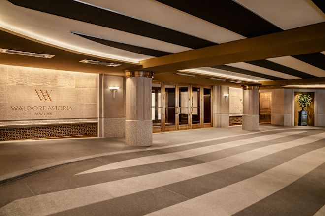 Hotel entrance, with Waldorf Astoria signage and plant