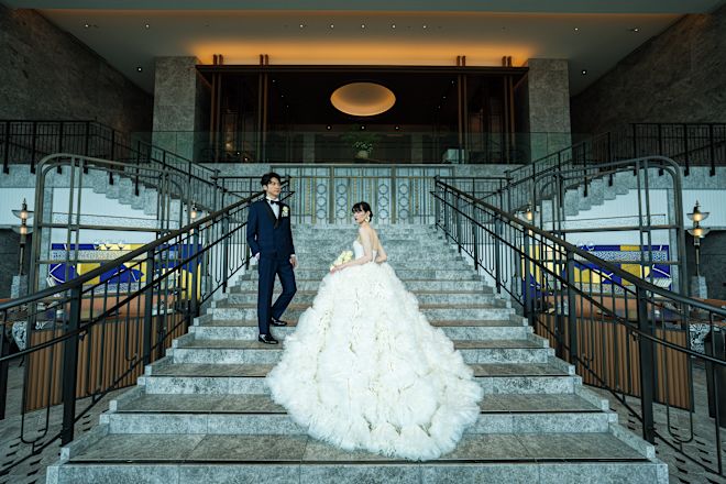 Bride and groom walking up a grand staircase.