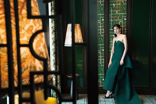 Bridesmaid standing against a wall.