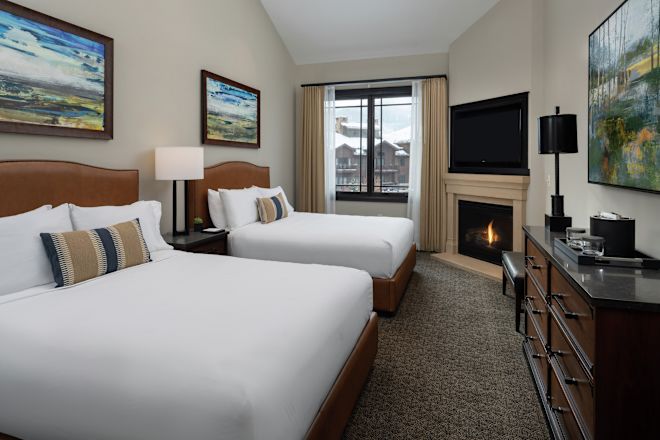 2 paturi în cameră cu televizor și șemineu