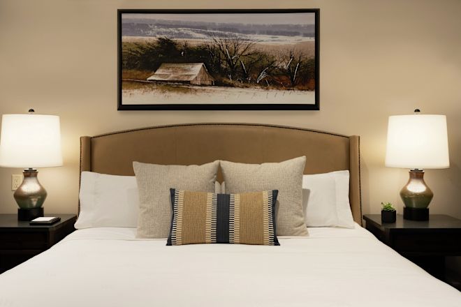 Dormiți în cameră cu artă pe perete și lămpi