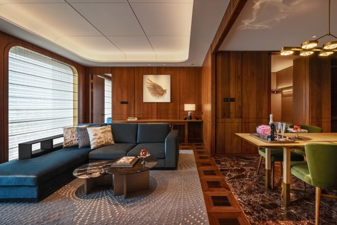 1ベッドルームスイートのリビングルームと青いソファ、グリーンの椅子