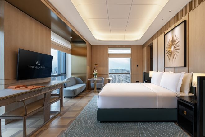 大きなベッド、ソファ、ハイビジョンテレビを備えたシティビューの客室