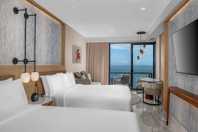 Two queen beds ocean front deluxe guestroom with wall mounted TV