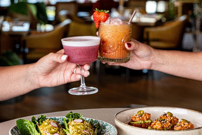 Thistle and Rye, guests toasting with cocktails, salad plate and appetizers