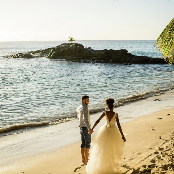 Pasangan pernikahan di pantai saat matahari terbenam